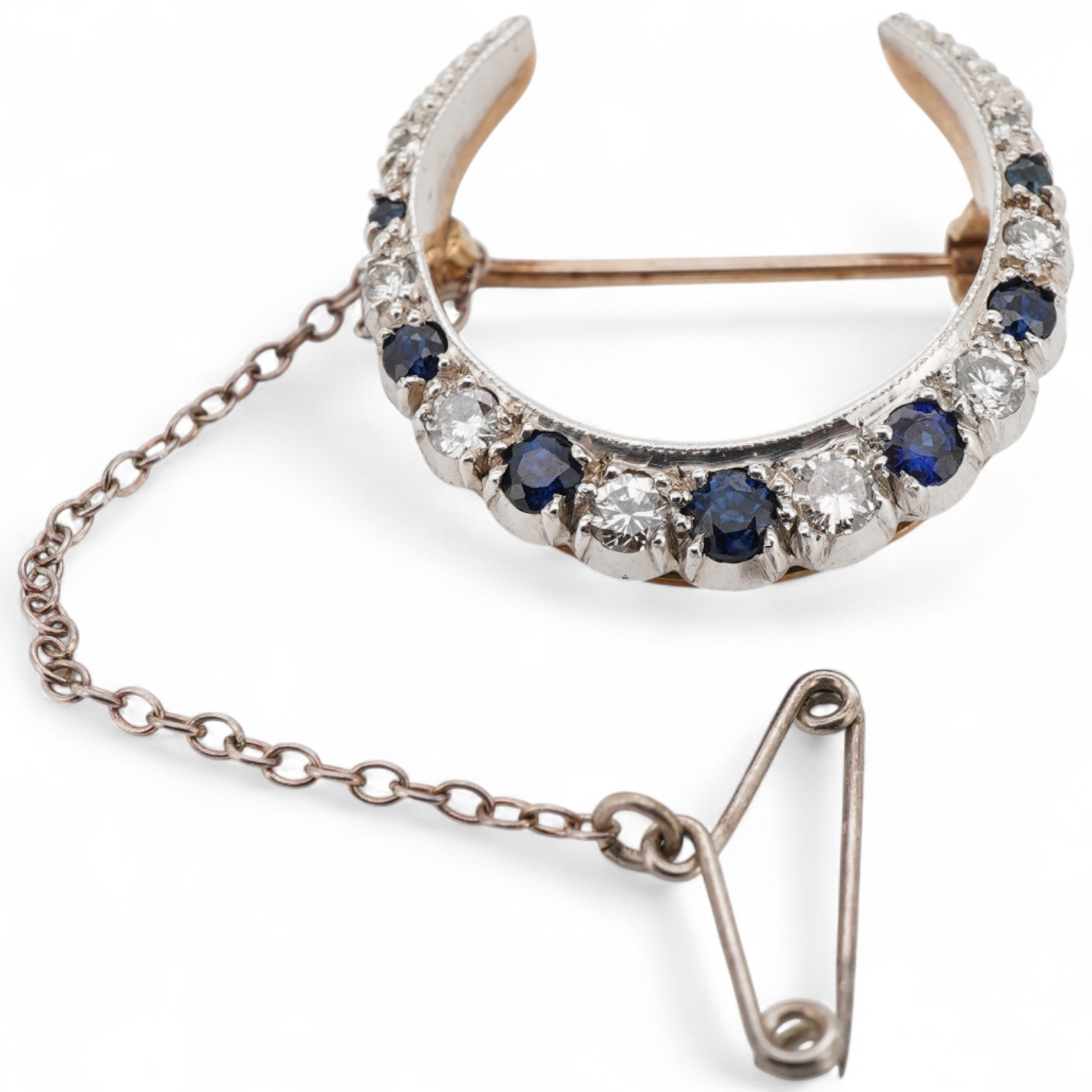 A 1970's Edwardian style 9ct gold, graduated sapphire and diamond set crescent brooch, 24mm.